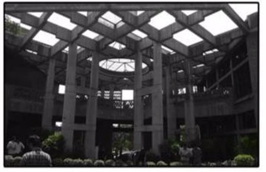 Black and white photograph of a concrete atrium frame with skylights overhead.