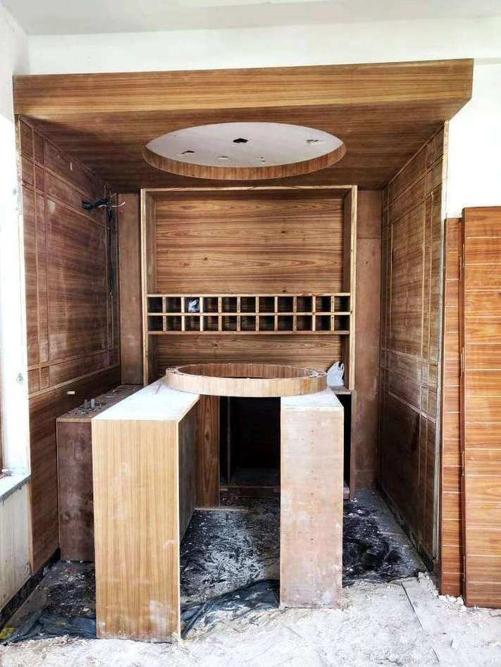 Site photograph of the bar under construction: timber panelling installed around the counter and the circular ceiling recess formed.