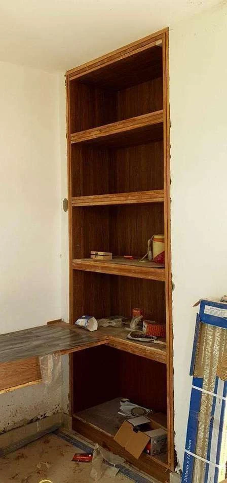 Site photograph of the bedroom bookshelf carcass built into the corner recess.