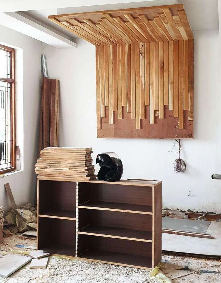 Site photograph of the bedroom console and slatted wooden wall panelling being installed.