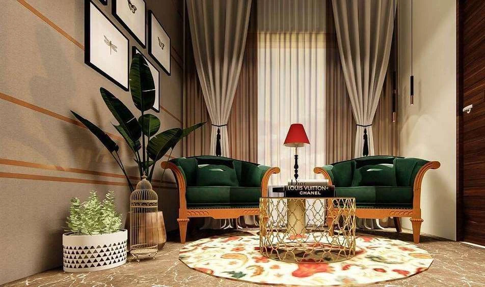 Seating corner of the entertainment room with green upholstered classical armchairs, a red table lamp and an oversized plant.